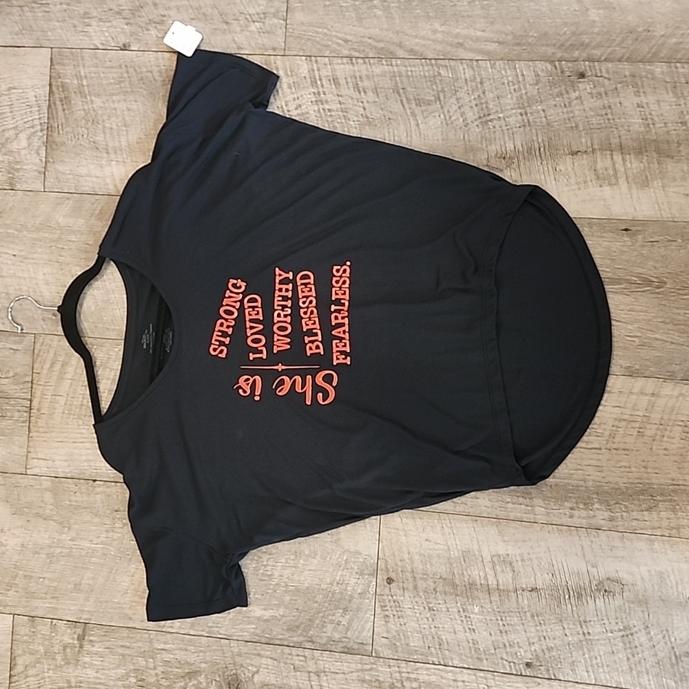 Black T, shorter in the front, soft, She is Strong